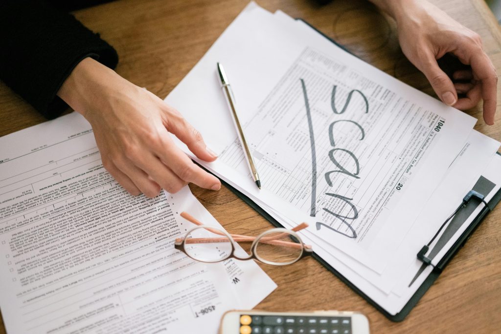 A close look at tax forms marked with scam, highlighting financial fraud risks.